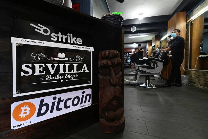 A barber shop displays a sign  that it accepts bitcoins in San Salvador. On Tuesday, the small central American nation of El Salvador will become the first in the world to make bitcoin legal tender