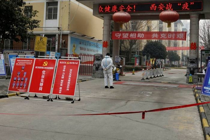 A man in a protective suit stands guard at an entrance of a residential compound in Xi’an in China’s northern Shaanxi province